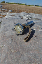 Siebe Gorman diver torch AP 4456 – front view on rock with beach background